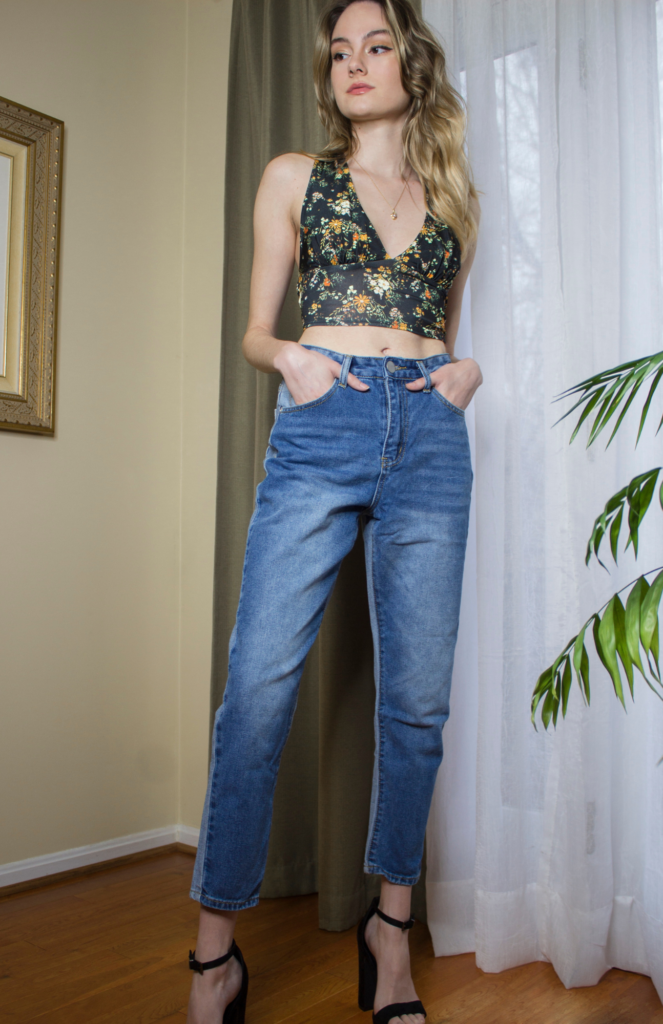 Front view: Stunning wrap-around tank from Urban Outfitters, a versatile match with denim. Admire the vibrant orange floral details against the two-toned blues. The contrast follows color theory, offering a complementary palette.