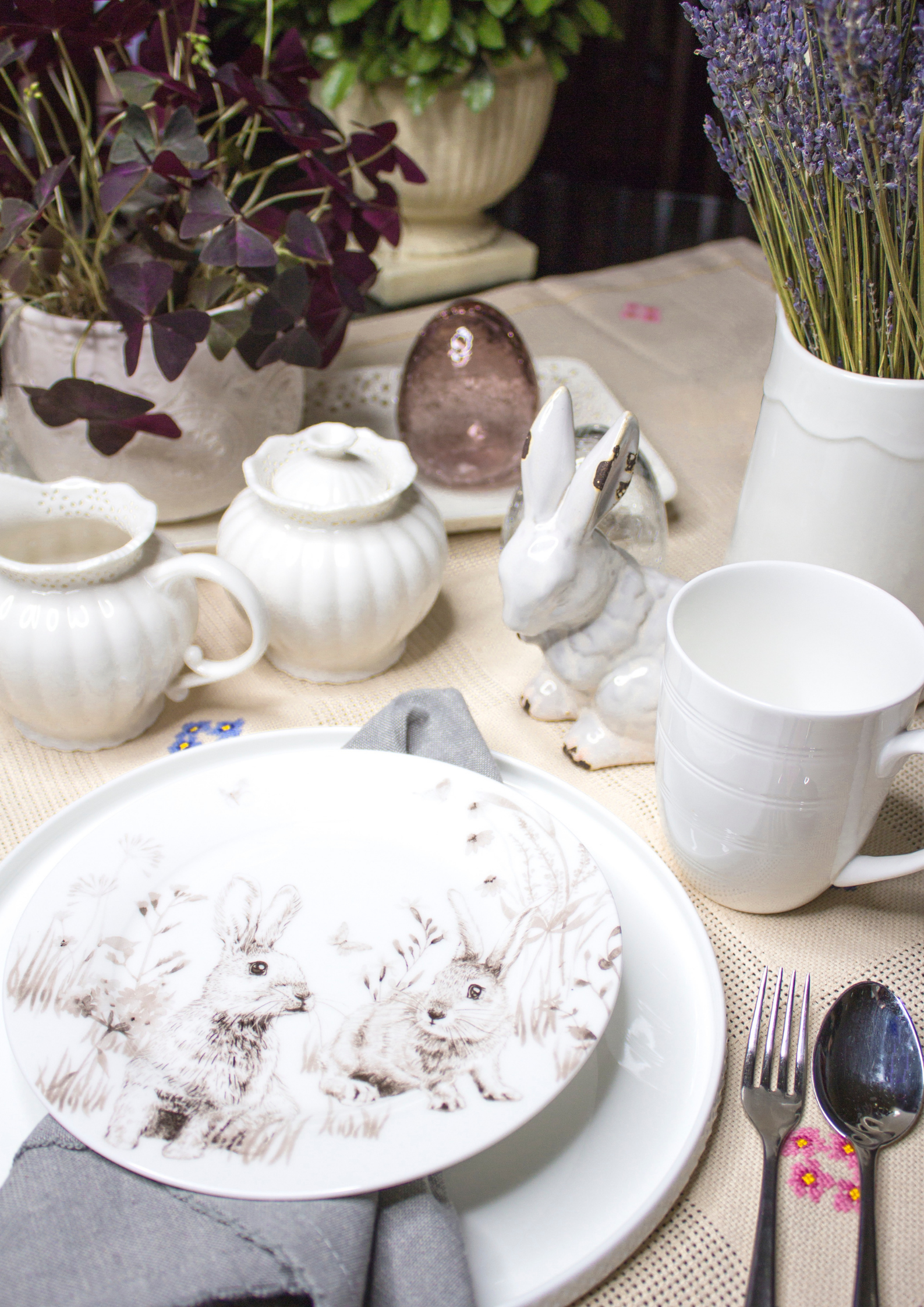 Image showcases a delightful mix of Easter celebration items, including a bunny figurine, a plate adorned with a bunny, vibrant Easter egg decorations, a variety of plants, and more.