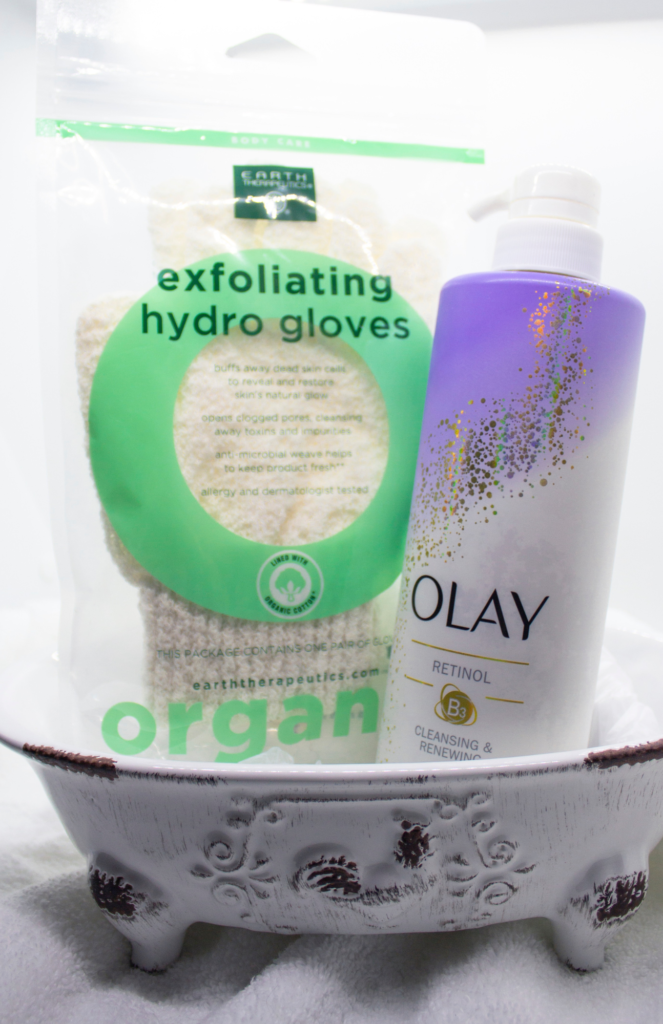 Miniature ornament bathtub showcasing Olay Cleansing & Renewing Nighttime Body Wash and Earth Therapeutics Organic Cotton Exfoliating Gloves, for a body care routine! 