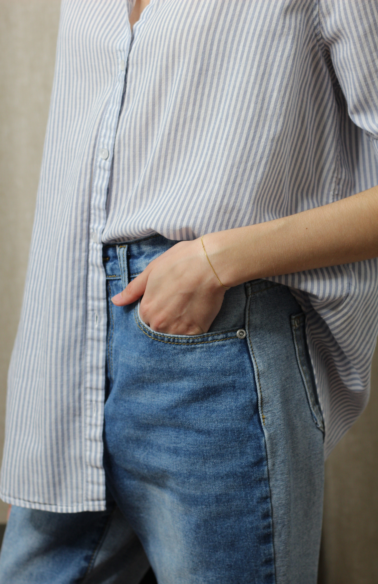 Content creator in Light Blue Striped Shirt with Monochromatic Fashion half-tuck and Jeans.