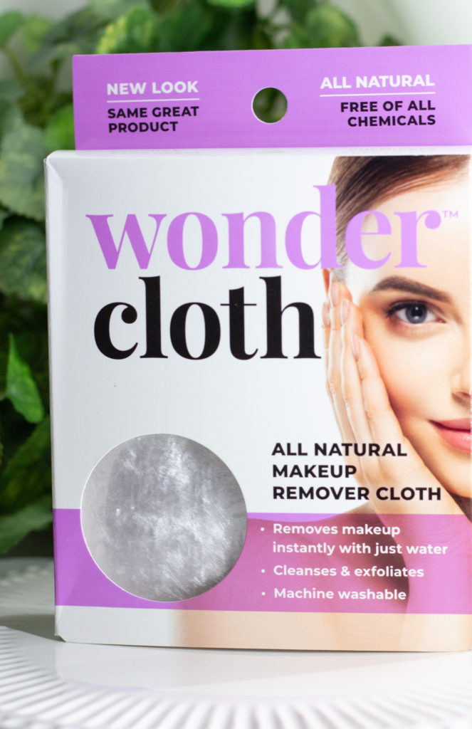 Wonder Cloth package in its new look with the same great product. The packaging features a white and dusty rose color scheme with text in white and black, emphasizing its eco-friendly, chemical-free, and hypoallergenic qualities. The right side of the package shows a partial image of a woman's face, wrapping around to the side.