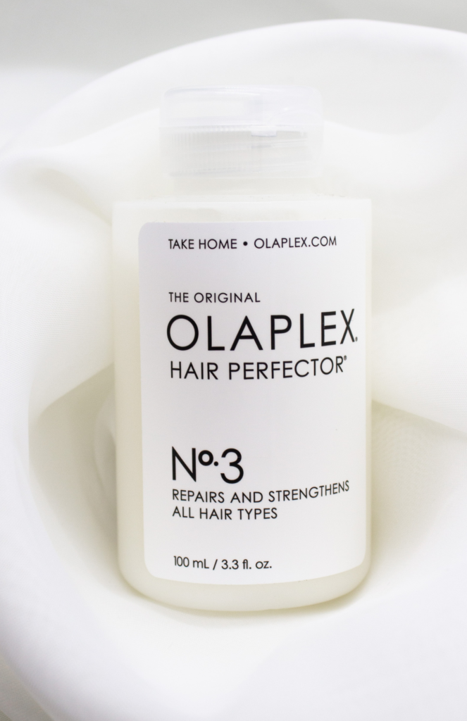 Olaplex No. 3 Hair Perfector bottle elegantly displayed against a soft white background, showcasing its sleek and modern design.