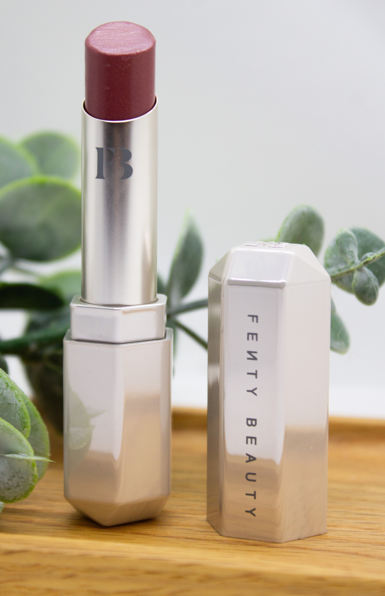 Fenty Slip Shine Sheer Shiny Lipstick in sleek packaging against a clean, white background.