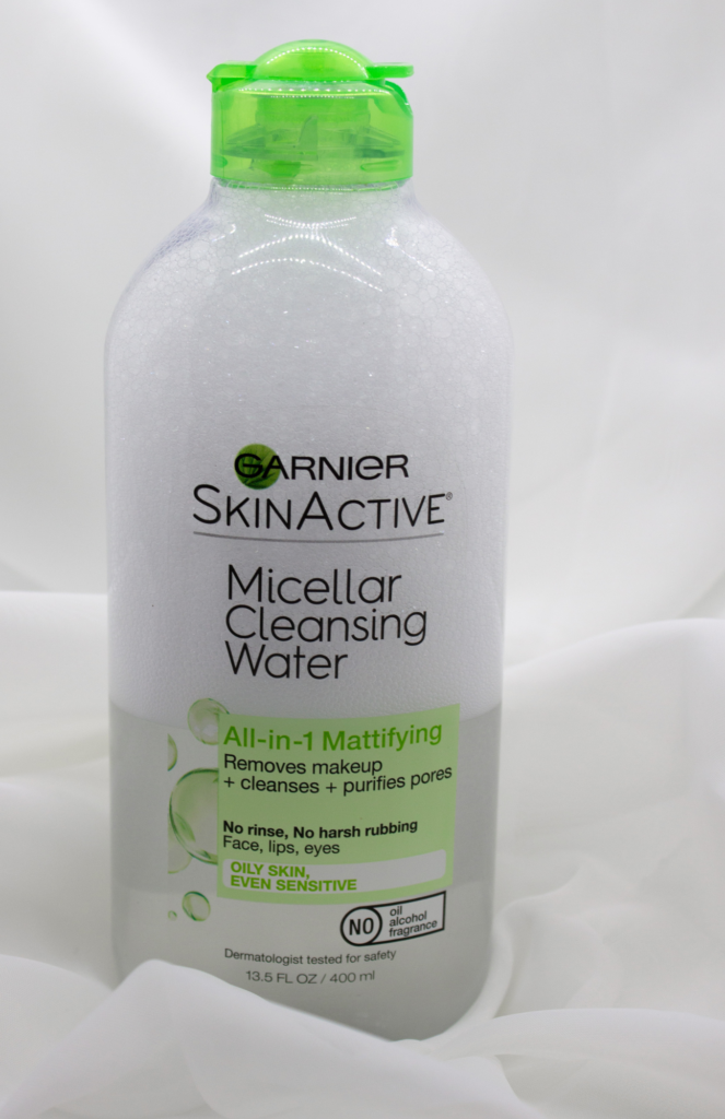 Clear bottle of Garnier Micellar Cleansing Water All-in-1 Mattifying displayed on a clean white background, featuring transparent liquid with green labeling. Nighttime Skincare.