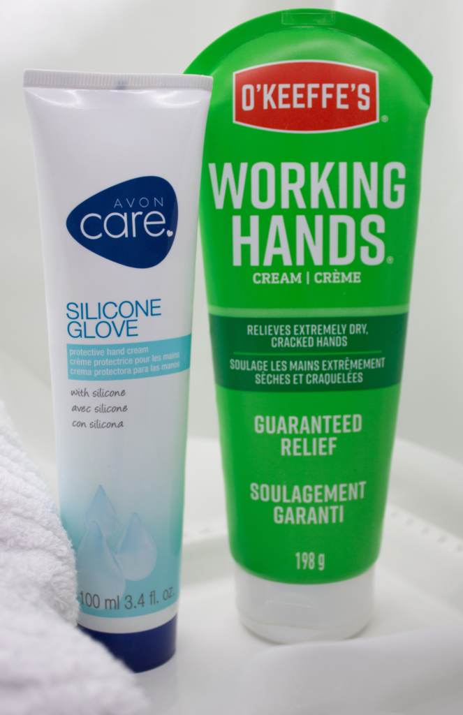 Two hand care creams, O’Keeffe’s Working Hands and Avon Care Silicone Glove, beautifully displayed against a soft, neutral background, emphasizing hydration and hand care.