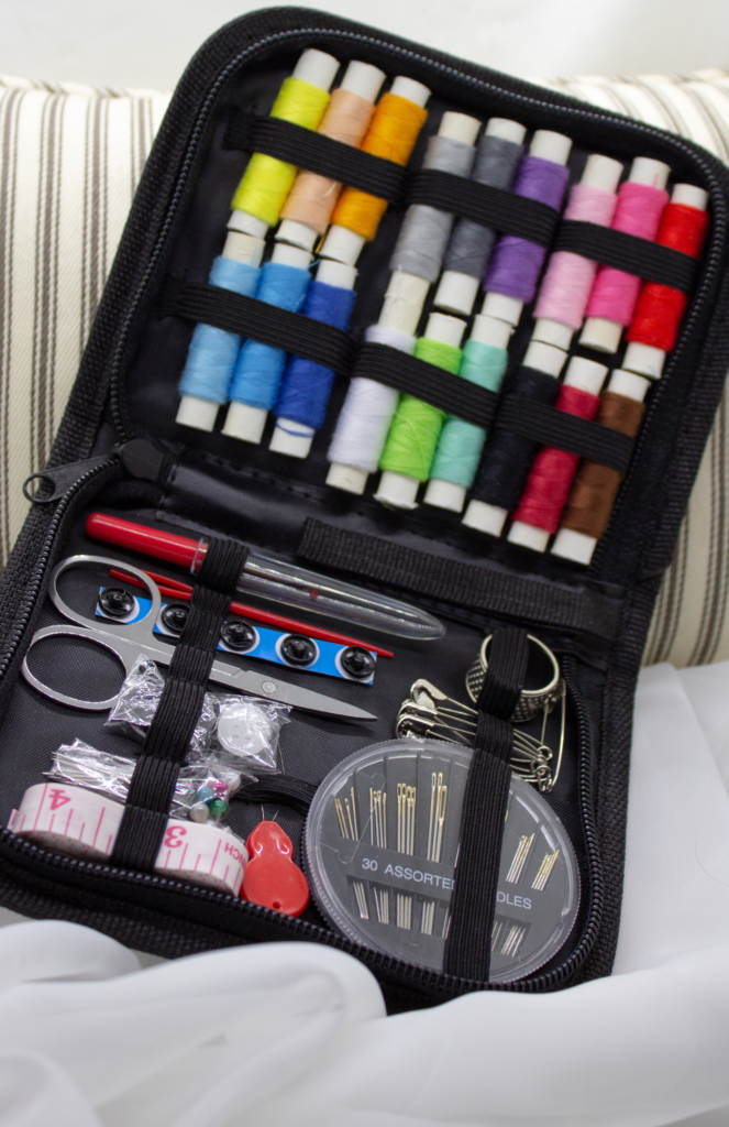 Compact sewing kit with thread, needles, and scissors for clothing repairs.