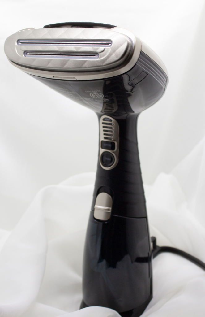 Handheld steamer used to smooth wrinkles and refresh delicate fabrics in a closet care routine.