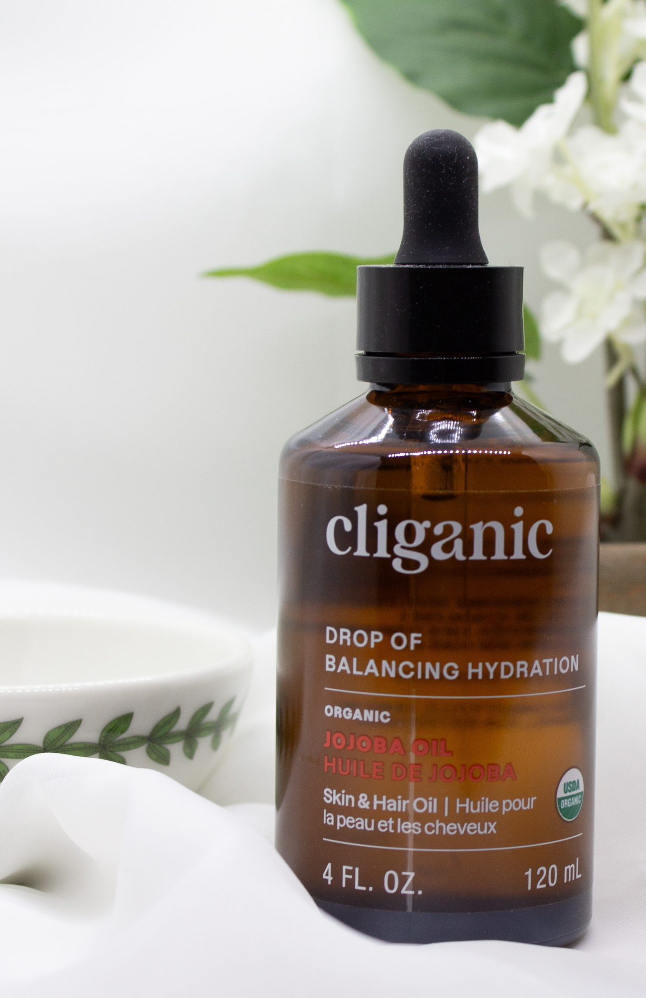 A bottle of jojoba oil on a soft white background, perfect natural ingredient for brittle nails and nourishing nail care.
